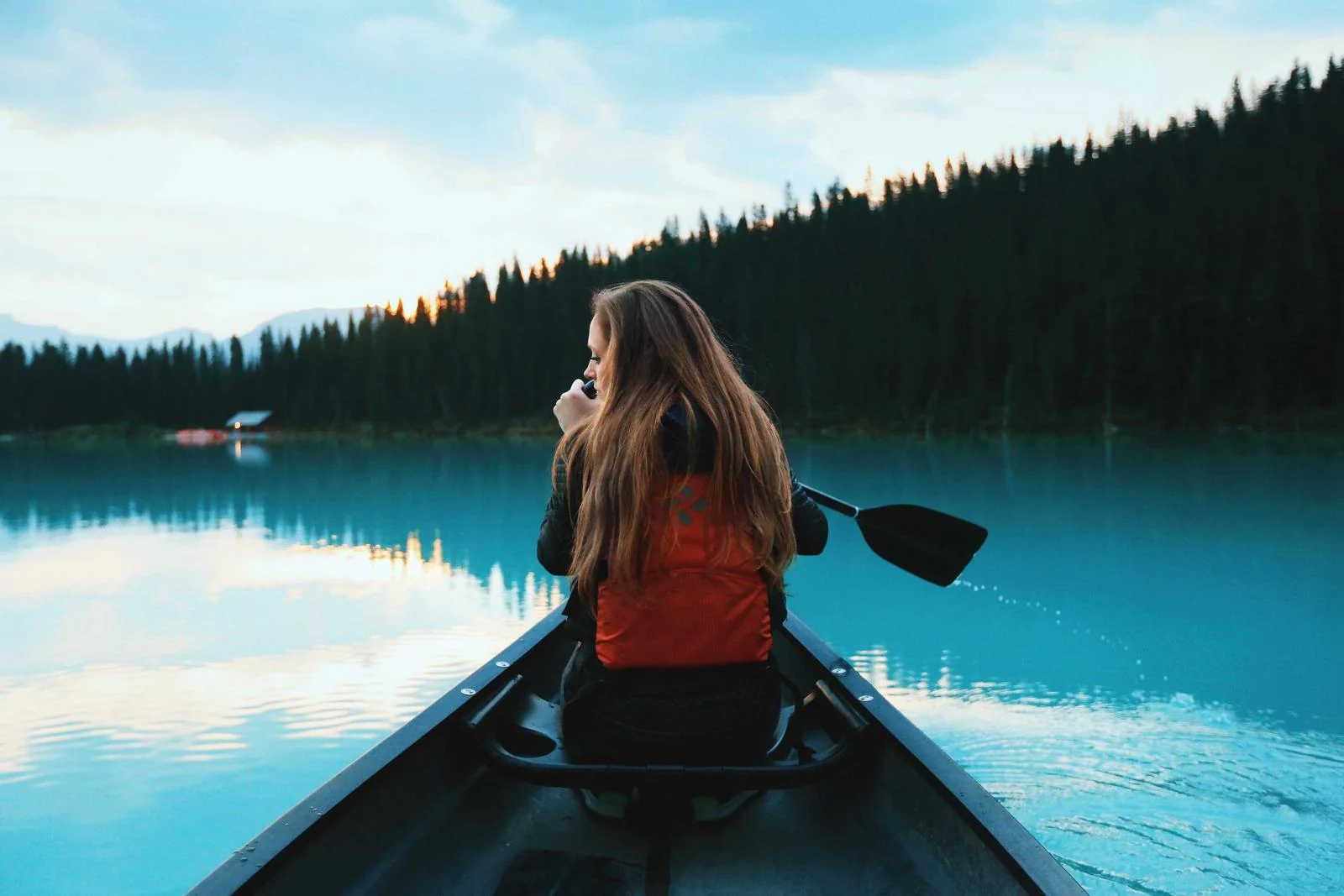 A person travelling across a lake in a canoe